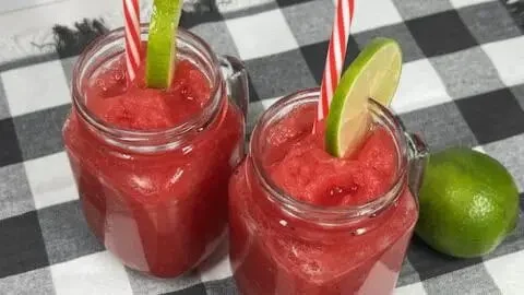 Refreshing watermelon slushie in a glass with ice and mint leaves