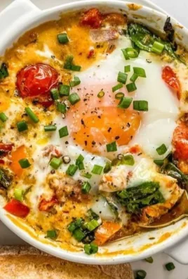 Baked feta eggs with tomatoes and spinach served in a dish