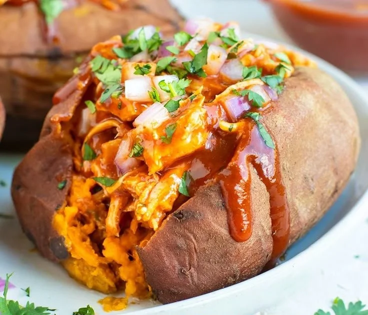BBQ chicken stuffed in sweet potatoes, garnished and ready to serve.