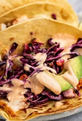Delicious fish tacos topped with fresh ingredients and served on a plate.