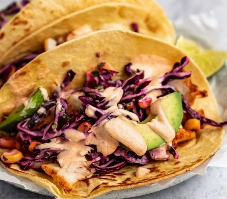 Delicious fish tacos topped with fresh ingredients and served on a plate.