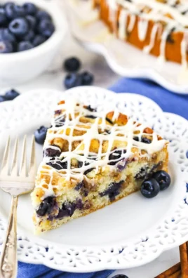 Blueberry streusel coffee cake with fresh blueberries on a plate.