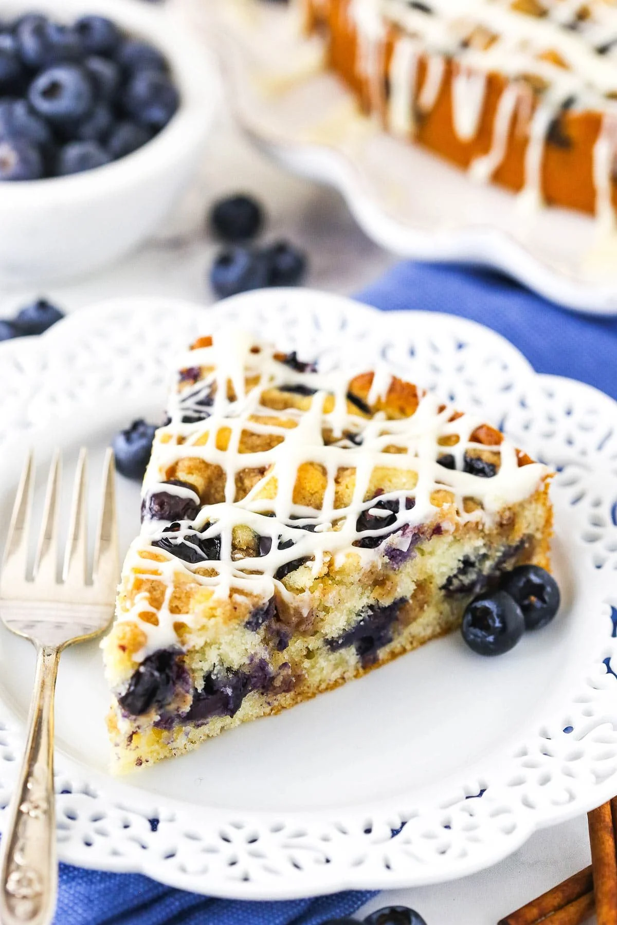 Blueberry streusel coffee cake with fresh blueberries on a plate.