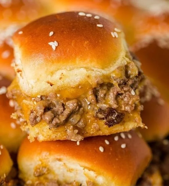 Plate of homemade cheeseburger sliders with fresh toppings and condiments