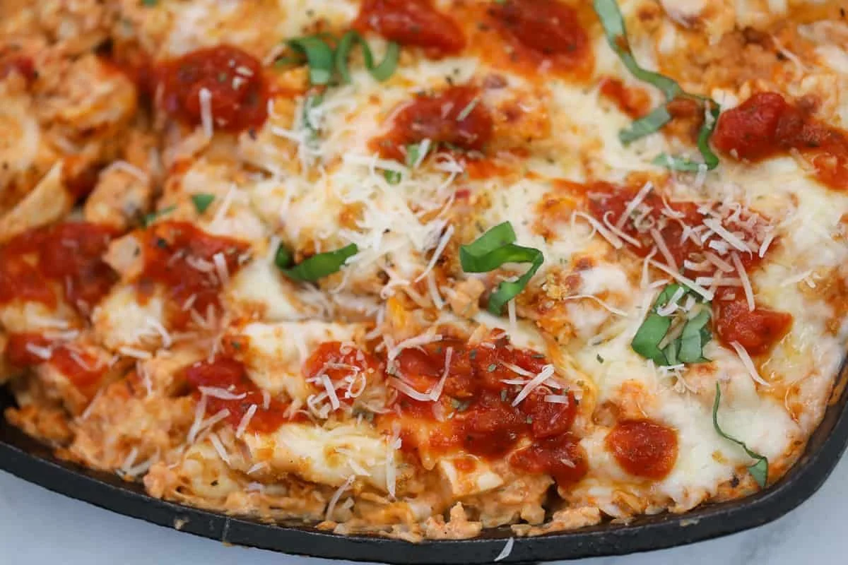 Delicious Chicken Parmesan Casserole topped with melted cheese and herbs.
