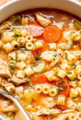 Bowl of homemade chicken soup with vegetables and herbs