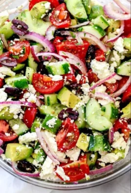 Delicious Greek salad with avocado, tomatoes, cucumber, feta, and olives.