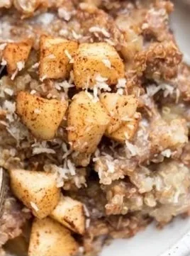 Healthy quinoa apple breakfast bowl topped with fresh apples and nuts.