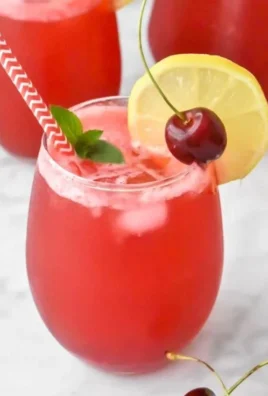 Refreshing homemade cherry lemonade served in a glass with lemon slices and cherries