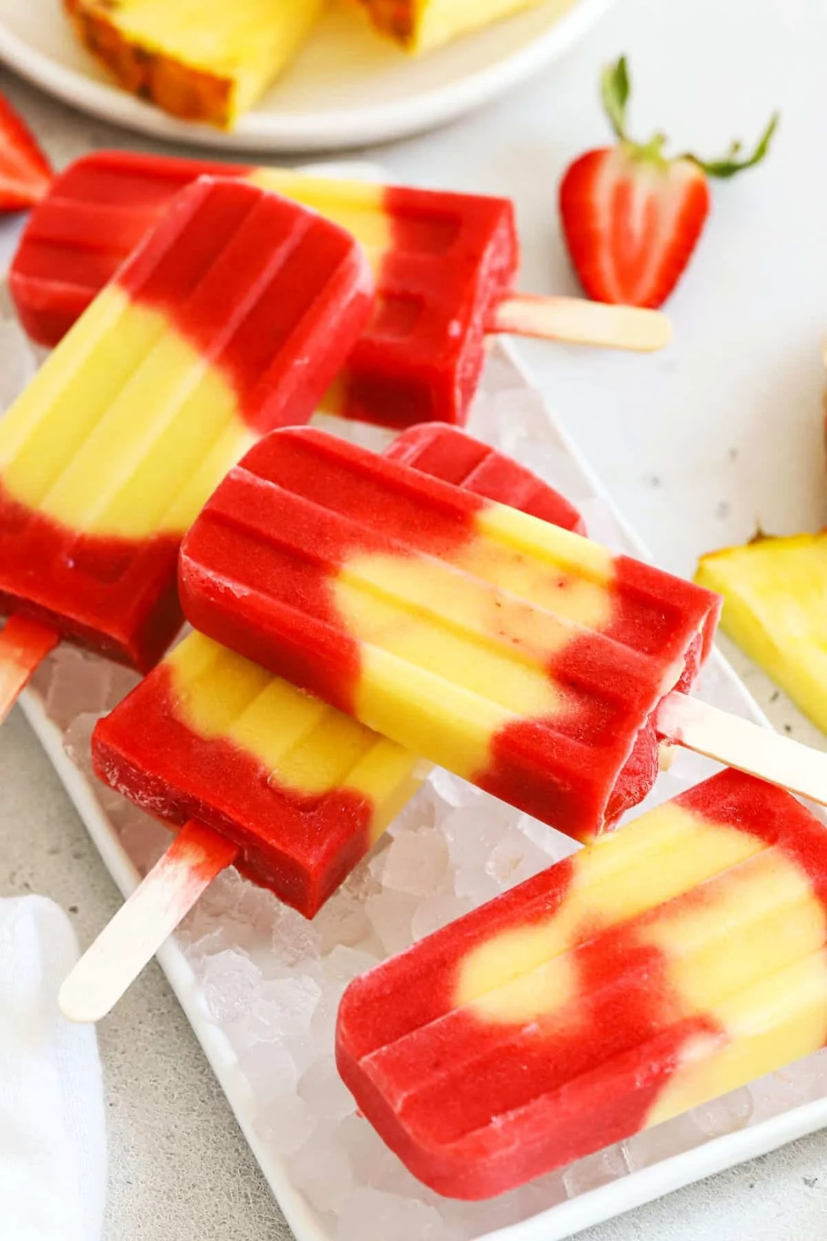 Colorful lava flow popsicles in a bowl, showcasing tropical flavors.
