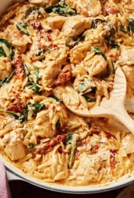 Plate of Marry Me Chicken Orzo garnished with herbs and served with a side salad