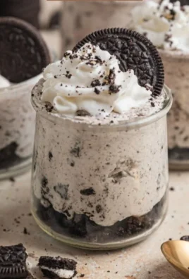 No bake Oreo cheesecake cups topped with crushed Oreos and whipped cream