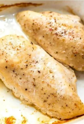 Oven baked chicken breast served on a plate with herbs and spices