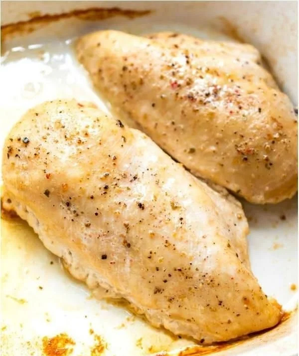 Oven baked chicken breast served on a plate with herbs and spices