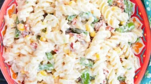 Delicious Pasta Salad topped with Creamy Parmesan Dressing in a colorful bowl.