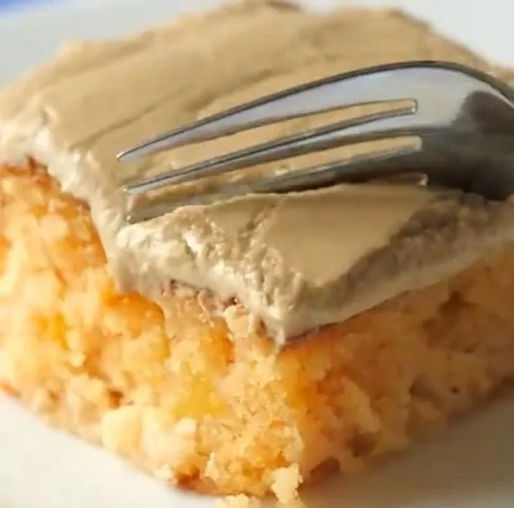 Delicious slice of peach cake topped with brown sugar frosting