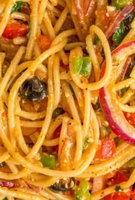 Colorful bowl of spaghetti salad with vegetables and dressing