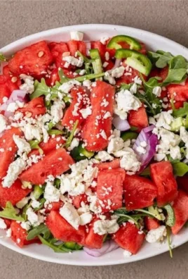 Spicy watermelon salad topped with hot honey for a refreshing summer dish.