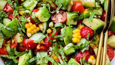 Summer salad with corn, strawberries, and avocado served in a bowl