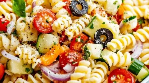 Colorful bowl of ultimate pasta salad with fresh vegetables and dressing